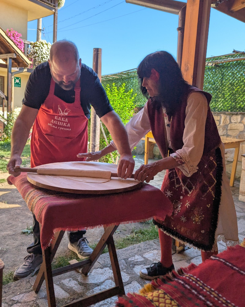 woman teaching man how to make banitsa in Bulgaria