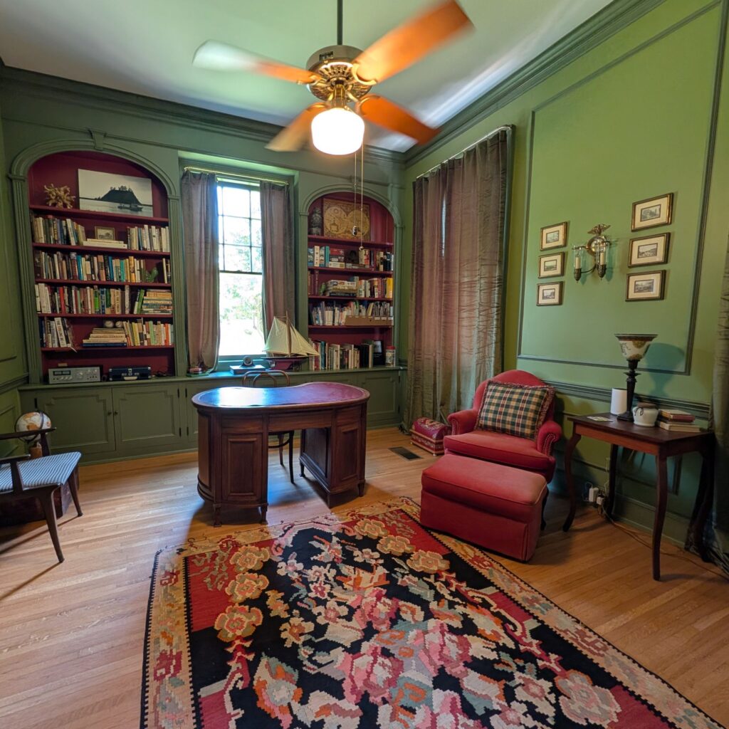cozy library with desk and reading chairs